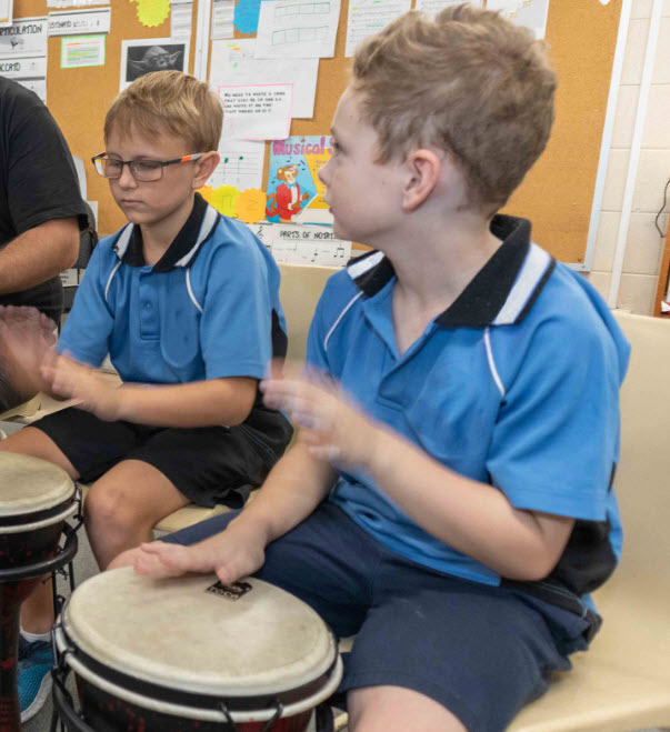 Two boys drumming in music class